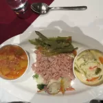 A Bhutanese meal in Paro: red rice with green beans, a bowl of vegetables in cheese sauce and a bowl of curry