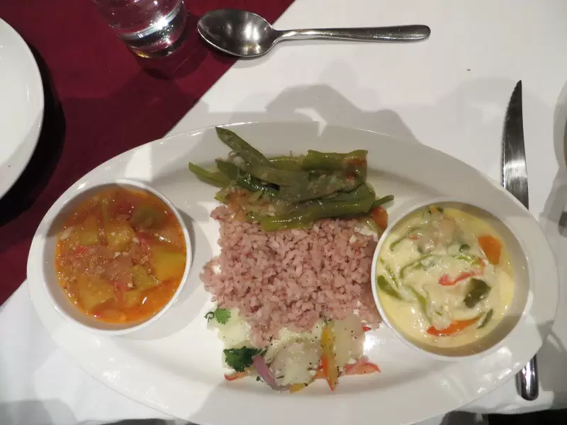 A Bhutanese meal in Paro: red rice with green beans, a bowl of vegetables in cheese sauce and a bowl of curry