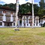 The temples of Kurjey Lhakhang in Bumthang, with tall prayer flags in front