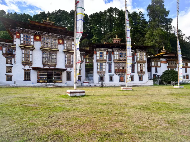 The temples of Kurjey Lhakhang in Bumthang, with tall prayer flags in front