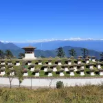 The 108 chortens on the Dochu La pass on a clear day, with the snow peaks of the Himalaya along the horizon