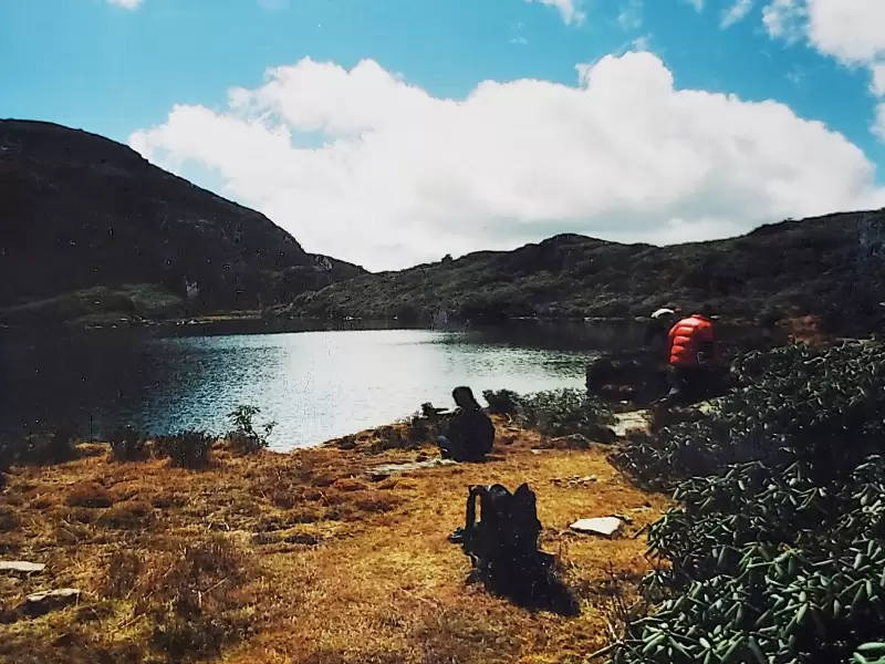 Jimilang Tsho, a lake high on the Druk Path, with walkers resting on its shore