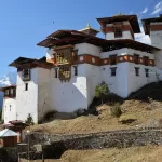 Gasa Dzong on its ridge, with snow peaks in the distance
