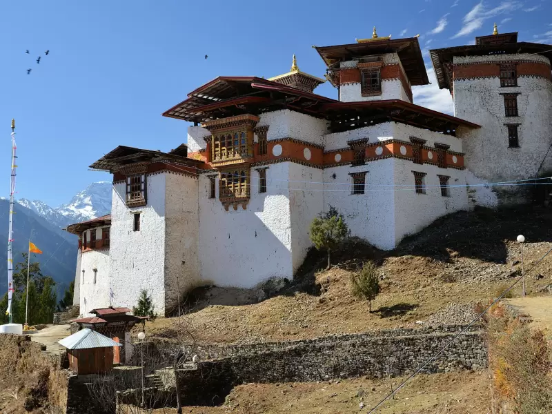 Gasa Dzong on its ridge, with snow peaks in the distance