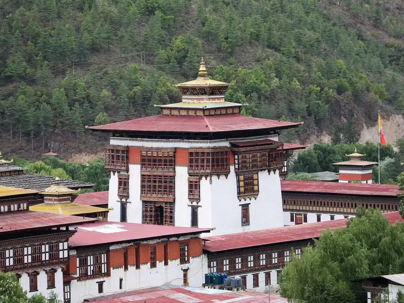 Tashichho Dzong in Thimphu, with its red roofs and white walls below a forested hill