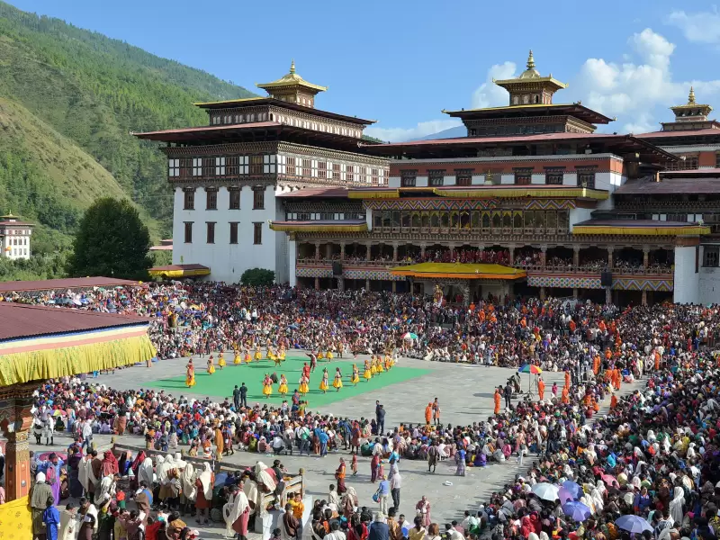 The festival ground beside Tashichho Dzong, crowded for Thimphu Tshechu, with dancers in the centre
