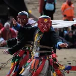 A masked dancer in mid-turn at a tshechu in Bhutan